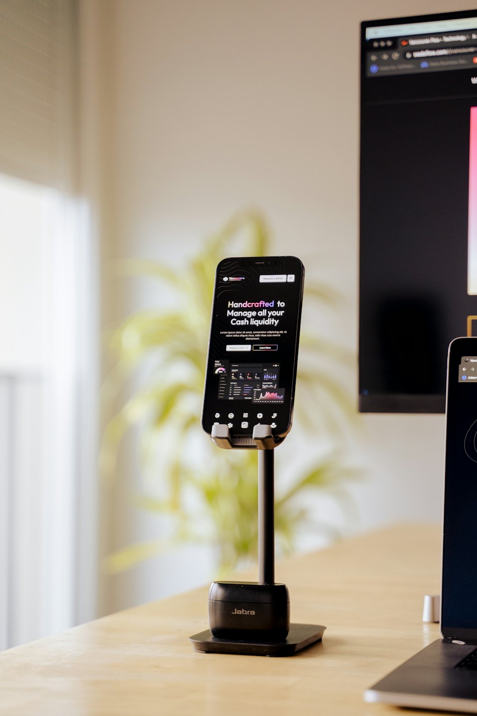 Smartfon na stojaku z wykresem biznesowym na biurku.